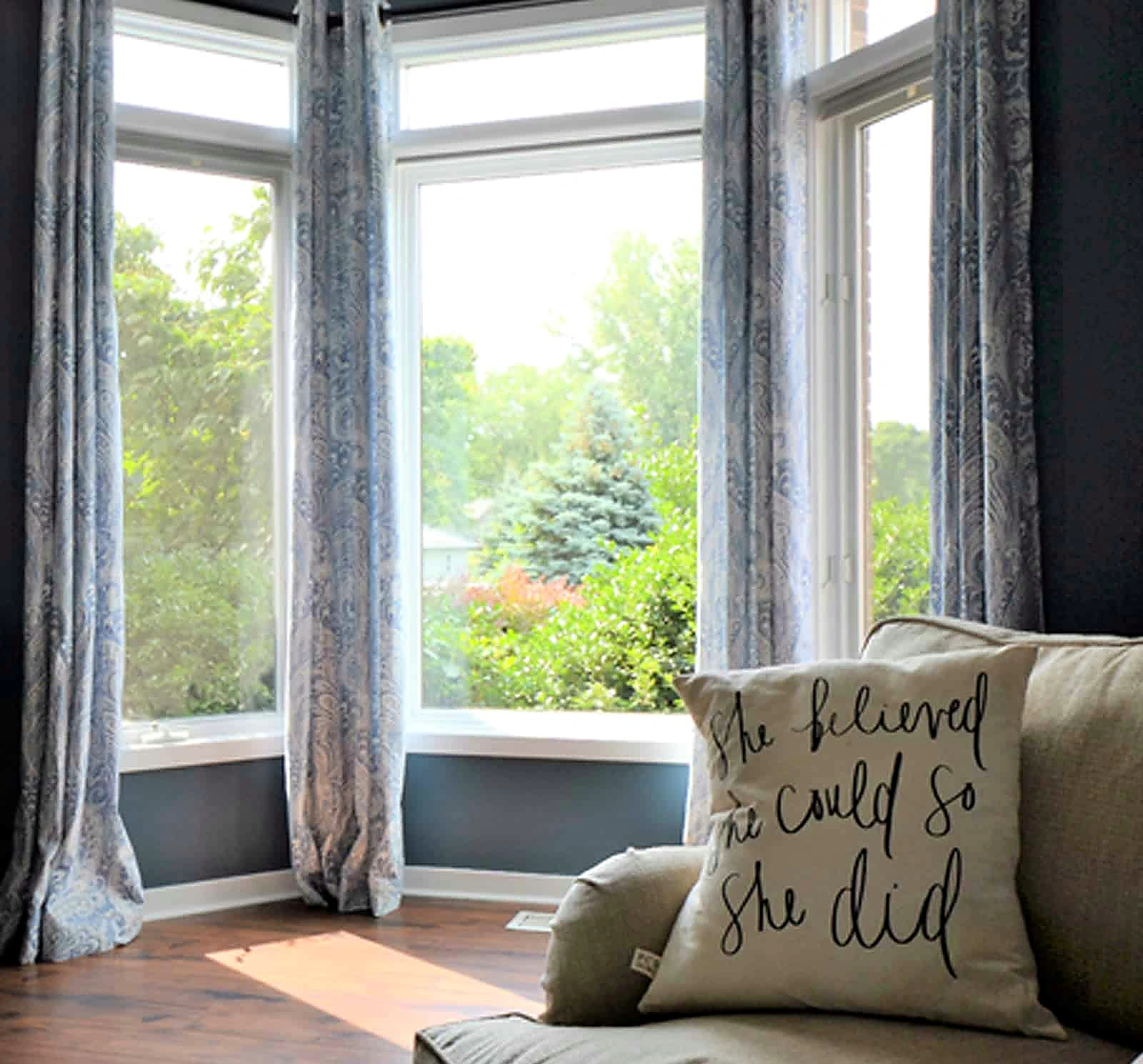 Bedroom with floor-length drapery and soft layered bedding